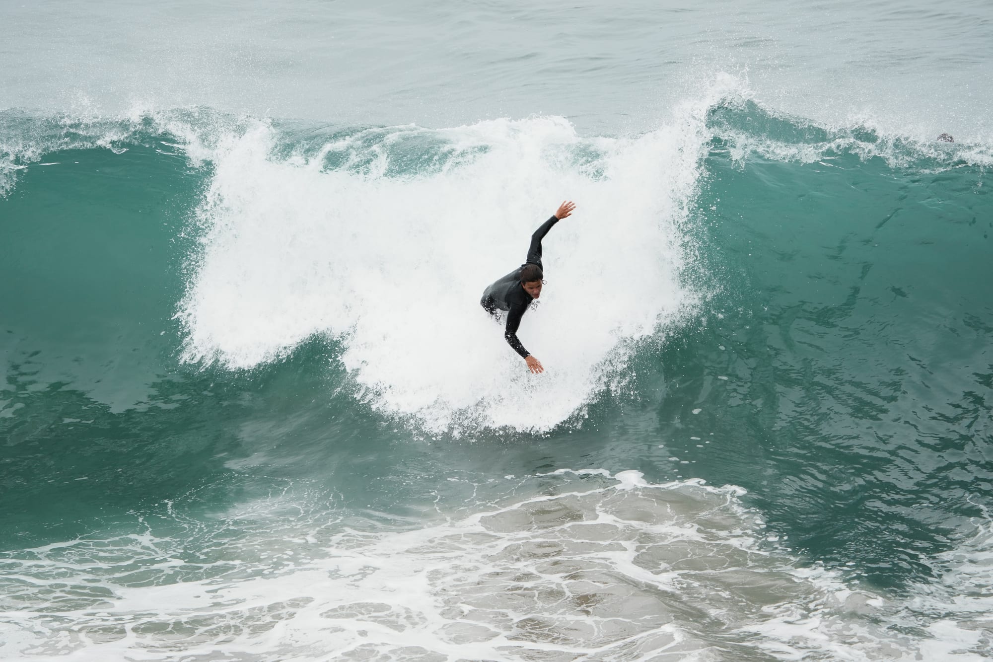 Surfer dropping down a big open face
