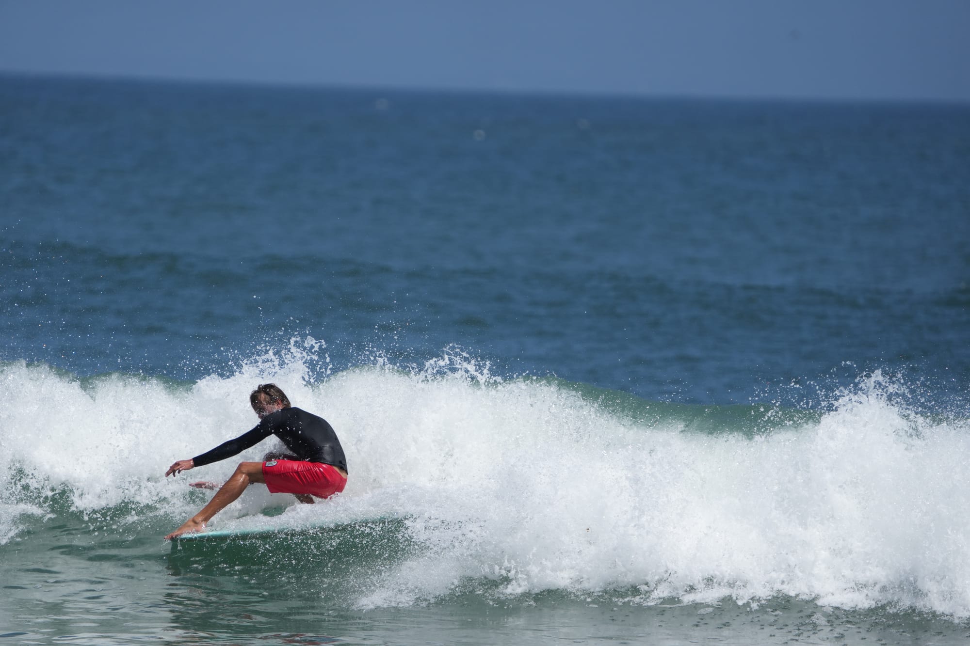 Surfer in red shorts off the top