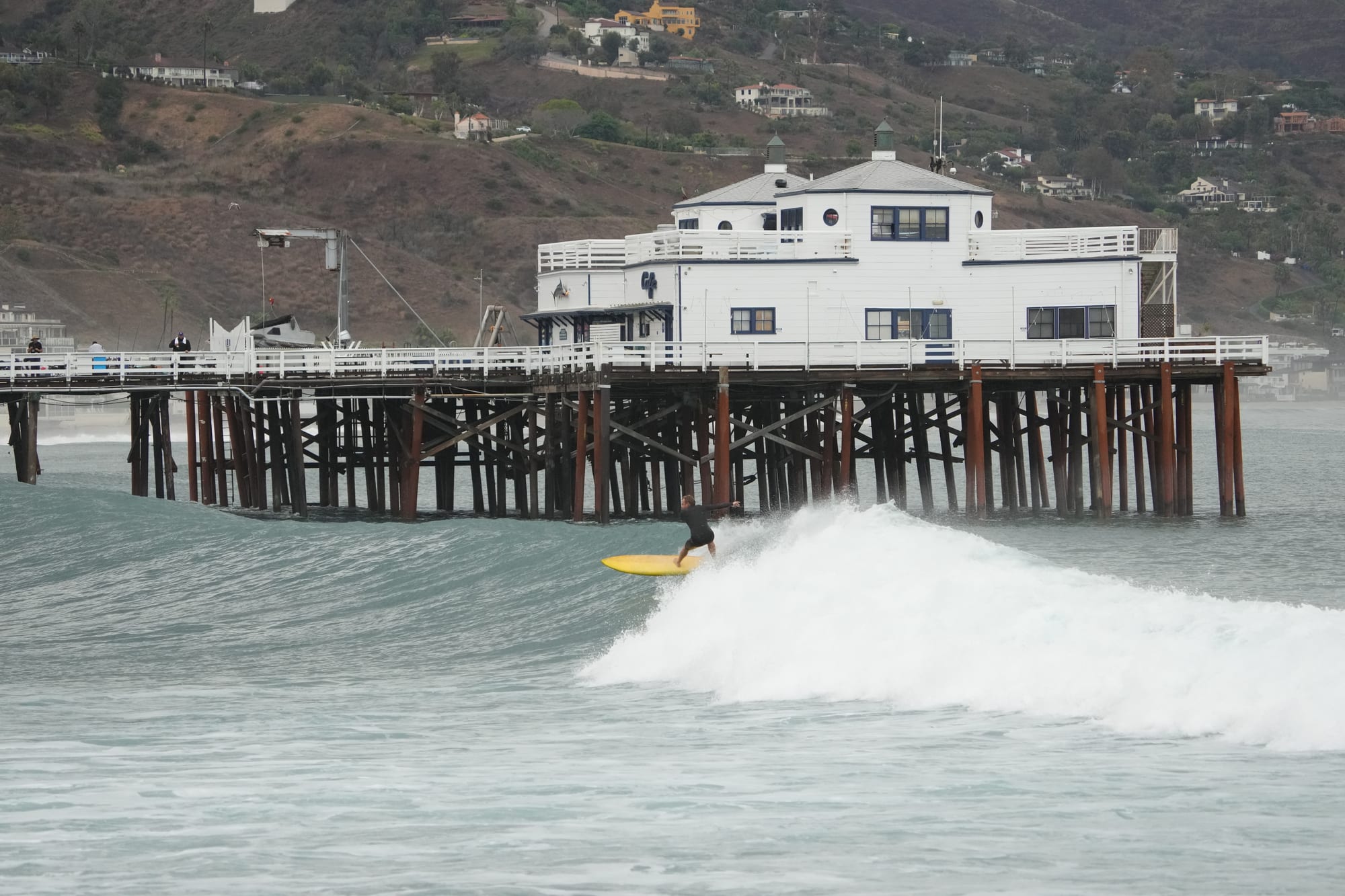 Surfer in front of the pier house