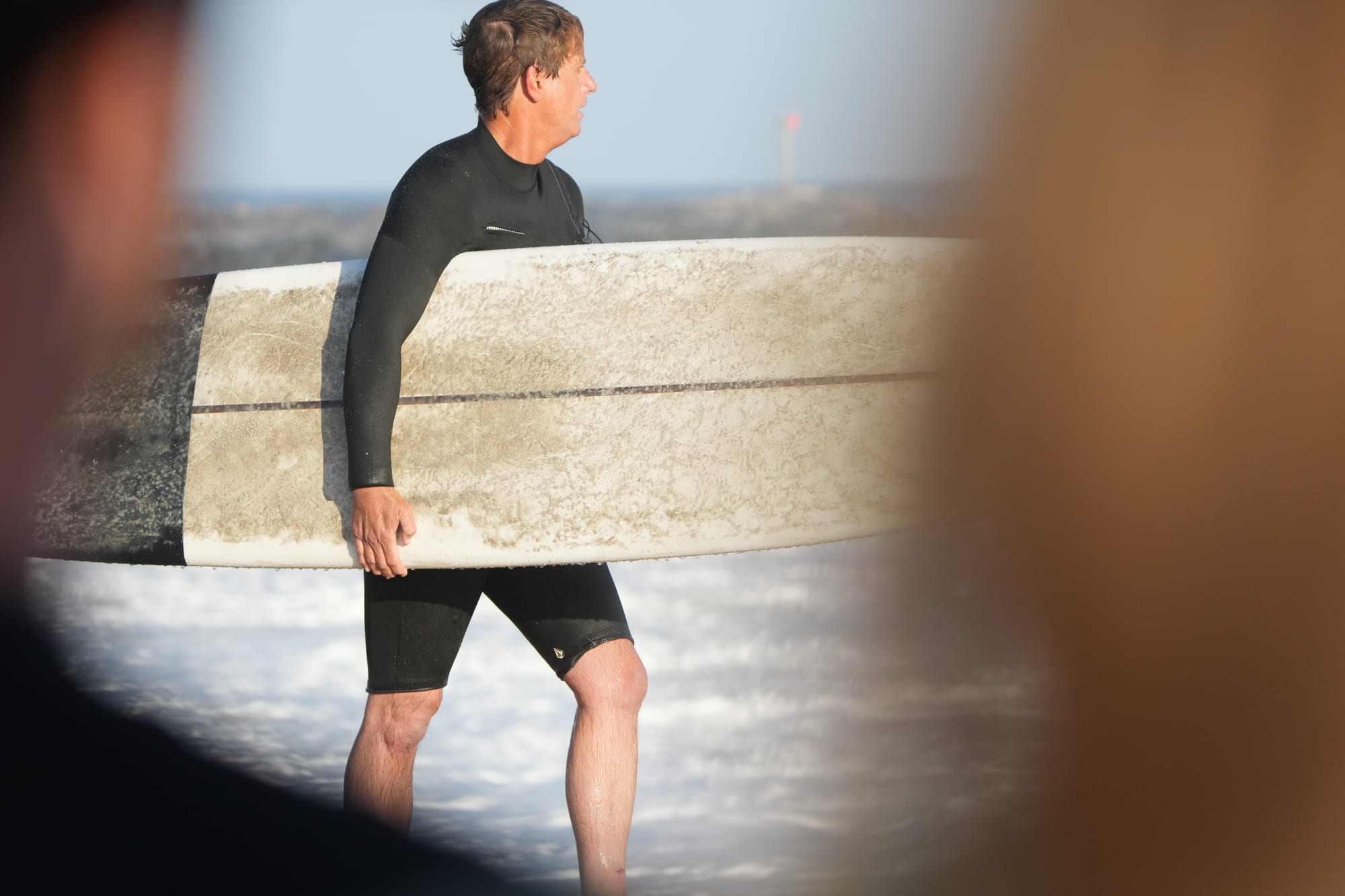 Board under arm before paddling out