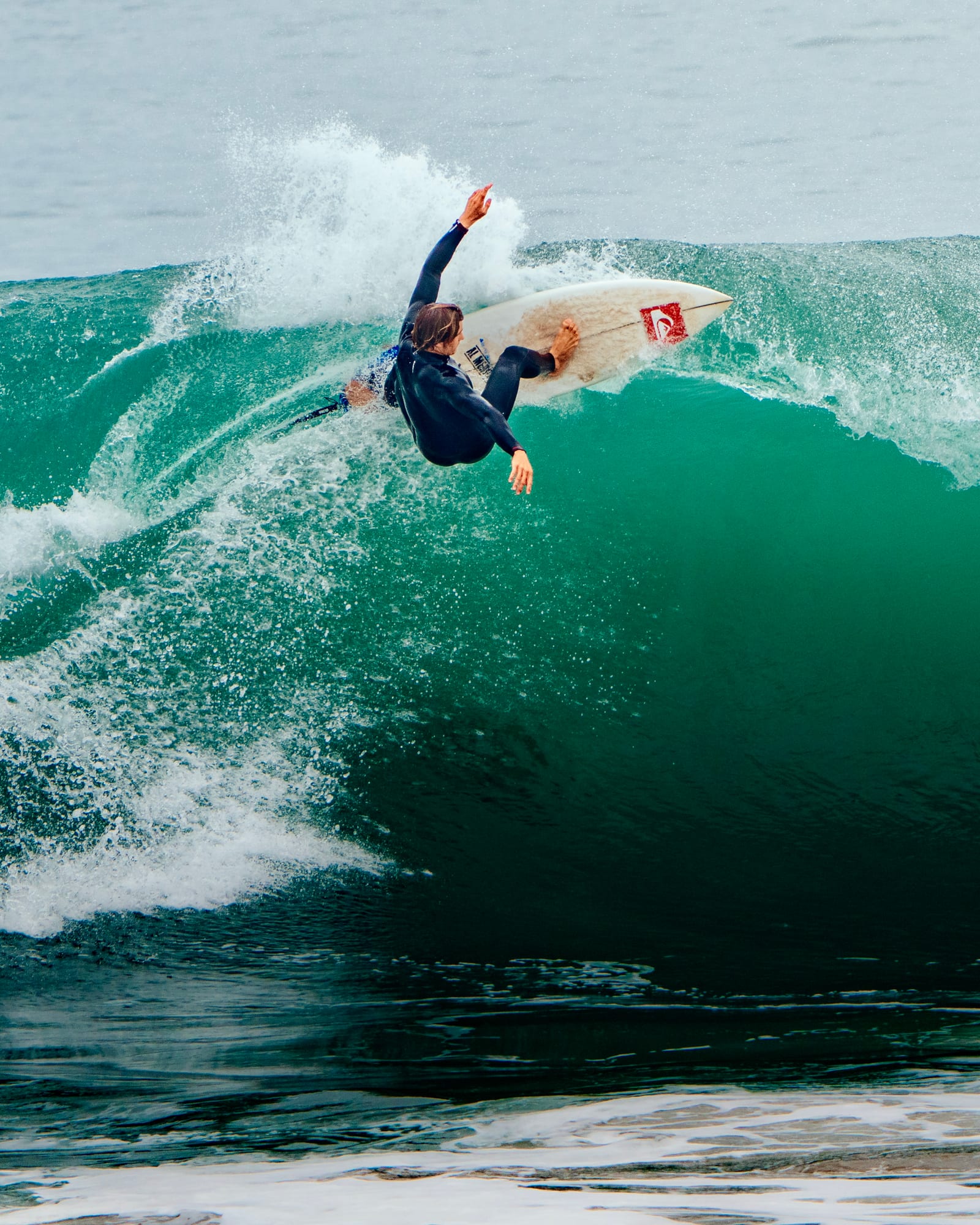 Surfer carving off the top of a green wave