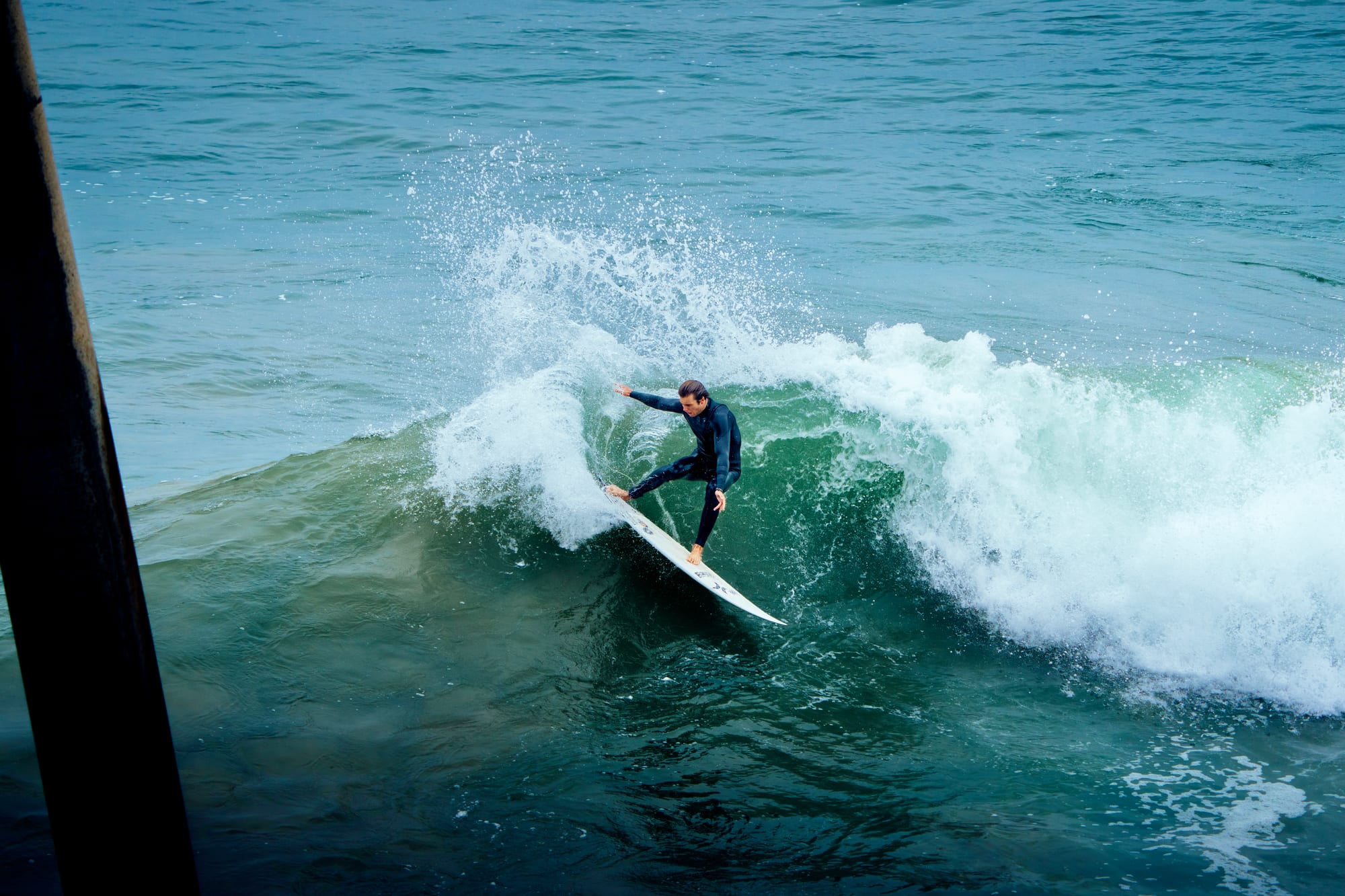 Surfer trimming down the line under a cliff