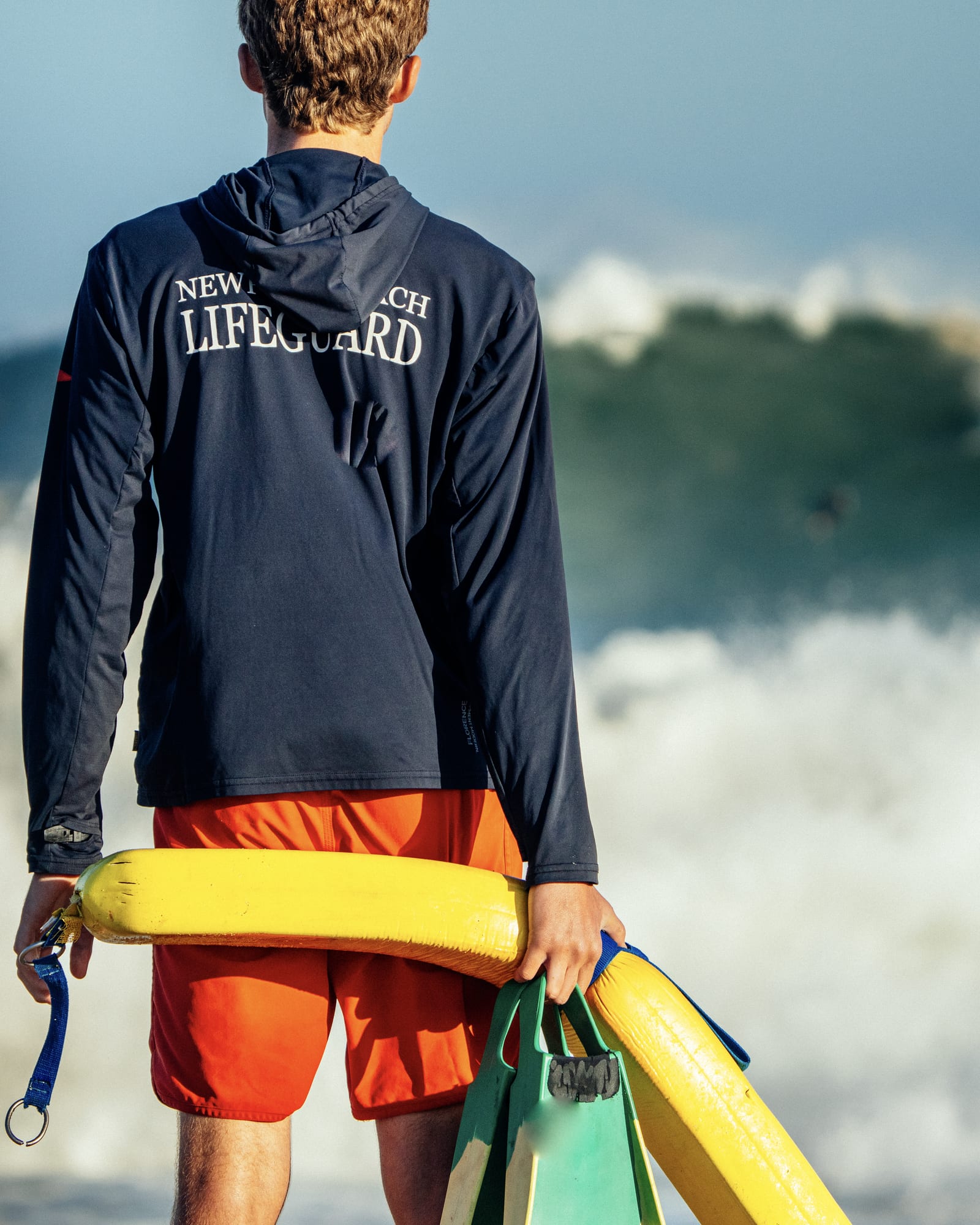 Lifeguard with a rescue can watching the surf