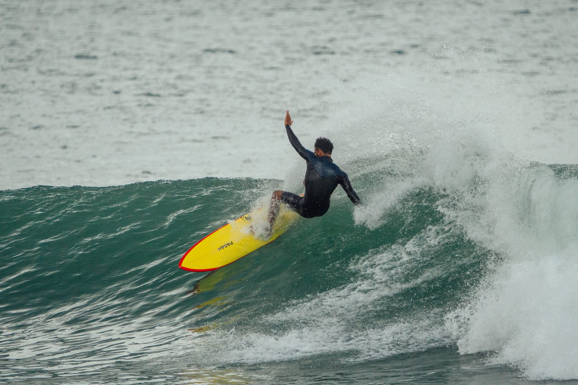 Surfer hitting the lip on a yellow board